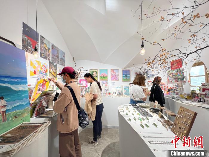 圖為藝術(shù)品商店內(nèi)，顧客挑選插畫作品。　鐘旖 攝