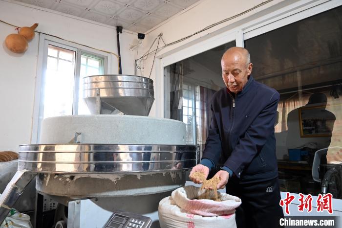 李家莊村民谷文朝重拾父輩的手藝，做起石磨面粉的營生?！〉杂鸺?攝