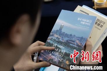 參展觀眾閱讀浙江文旅手冊?！《≌裾?攝