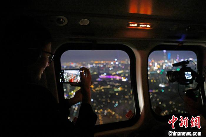 6月3日晚，游客乘坐上海新空直升機(jī)有限公司直升機(jī)開啟鳥瞰黃浦江空中圓夢(mèng)之旅，并用手機(jī)拍攝城市夜景?！∫罅⑶?攝