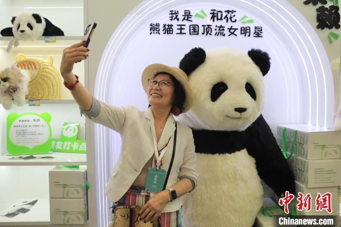 美國華視總裁楊蓮花與大熊貓文創(chuàng)產(chǎn)品合影?！⊥趵?攝
