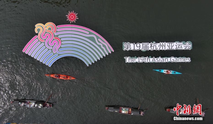 資料圖為烏篷船和皮劃艇從杭州亞運會標識前劃過。王剛 攝