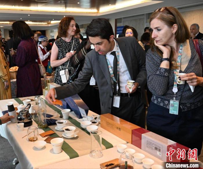 現(xiàn)場(chǎng)觀眾觀看中國(guó)展臺(tái)茶藝表演、了解茶文化。　靖樹 攝