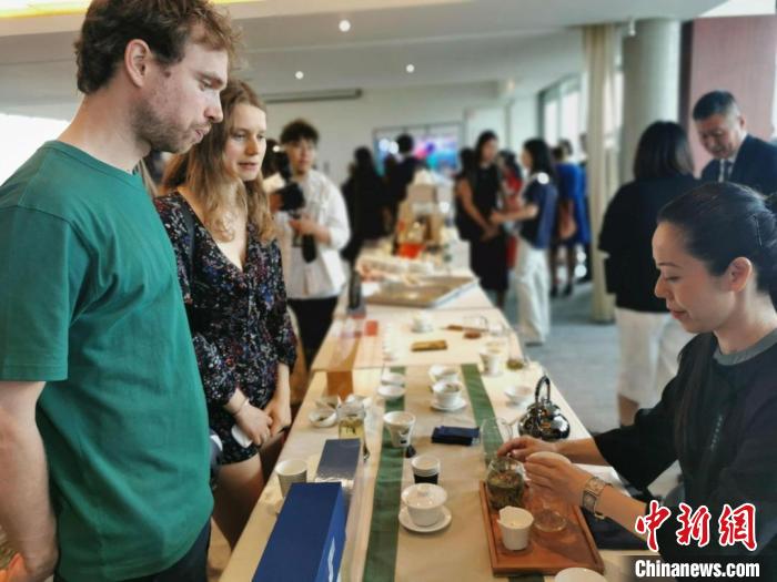 現(xiàn)場(chǎng)觀眾觀看中國(guó)展臺(tái)茶藝表演、了解茶文化?！【笜?攝