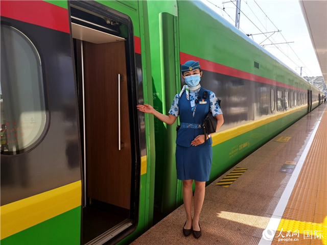 趙瑩靜站在“復興號”國際旅客列車車廂門口歡迎旅客上車。人民網(wǎng) 杜明明攝