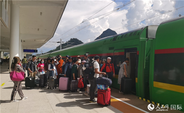 乘坐中老鐵路國際旅客列車的旅客在老撾瑯勃拉邦站排隊上車。人民網(wǎng)記者 杜明明攝