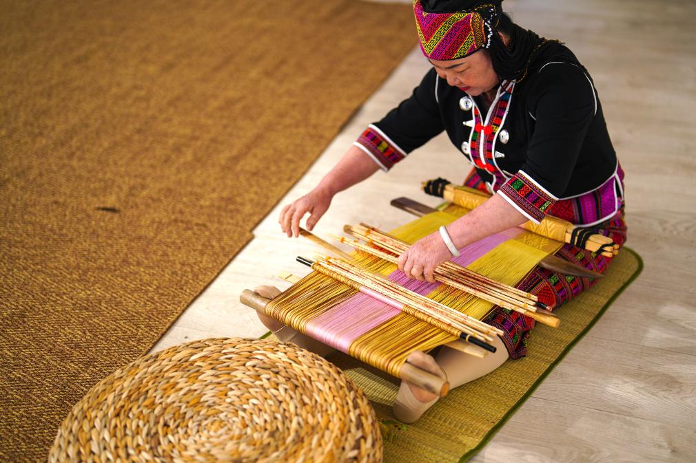 4月17日，黎族傳統(tǒng)紡染織繡技藝國家級代表性傳承人劉香蘭在2023年意大利米蘭設(shè)計周上展示黎錦織造技藝。新華社發(fā)