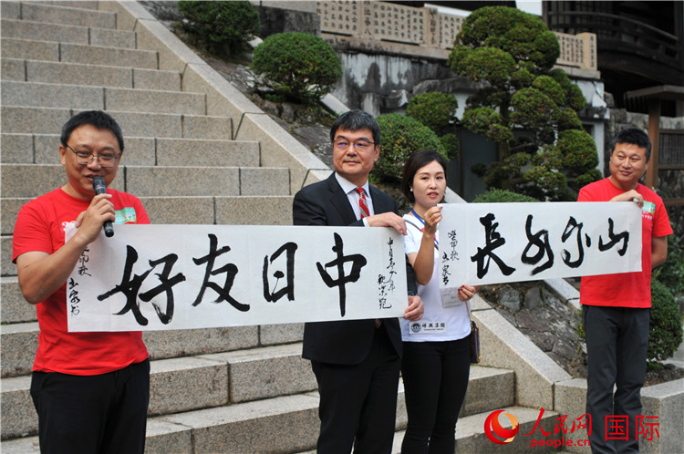 東京中國(guó)文化中心主任羅玉泉展示其為本次活動(dòng)書(shū)寫(xiě)的題詞“中日友好，山高水長(zhǎng)”。人民網(wǎng) 蔣曉辰攝
