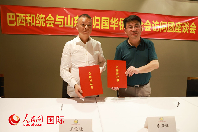 中國(guó)僑聯(lián)副主席、山東省僑聯(lián)主席李興鈺（右）與巴西和統(tǒng)會(huì)會(huì)長(zhǎng)王俊曉簽署合作協(xié)議書。人民網(wǎng)記者 陳海琪攝