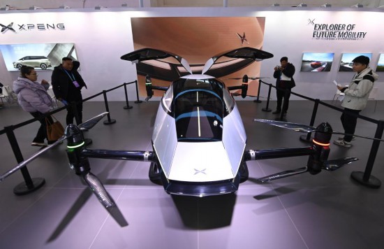 2023年12月1日，在鏈博會智能汽車鏈展區(qū)小鵬汽車展臺，參觀者觀看一臺智能飛行器。新華社記者蔡湘鑫攝