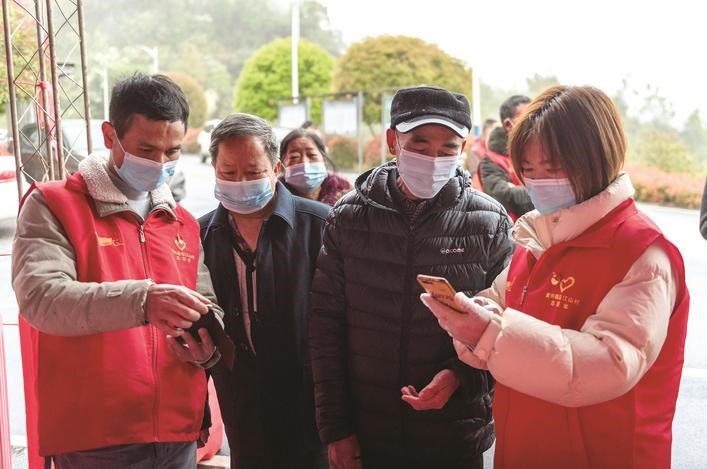長沙縣黨員志愿者正在幫助參與核酸檢測的群眾掃描“場所碼”。劉思源 攝
