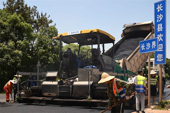 工人正在進(jìn)行“極薄磨耗層”路面的鋪筑。受訪單位供圖
