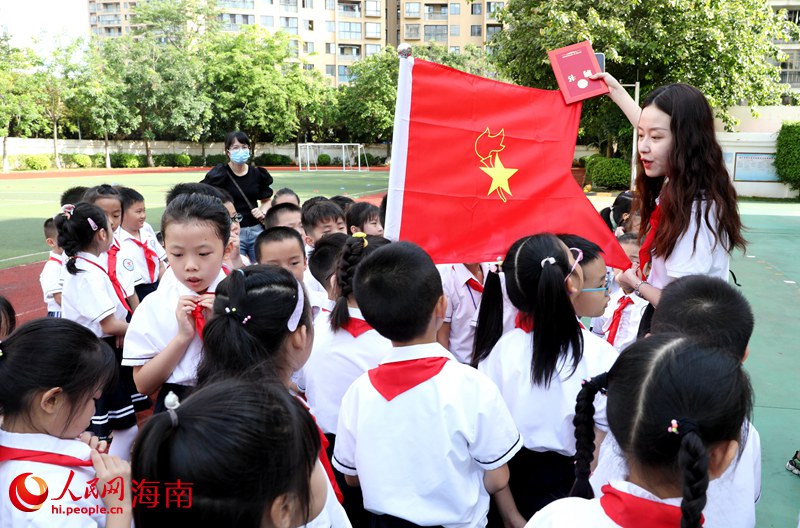 老師向少先隊(duì)員展示隊(duì)旗。人民網(wǎng) 符武平攝
