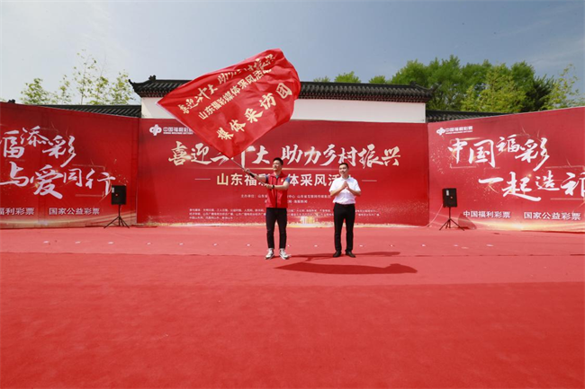為媒體采風(fēng)團(tuán)授旗。 山東省福彩供圖