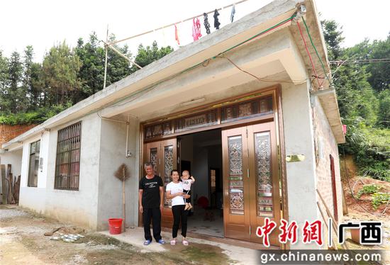 7月4日，在廣西柳州市融安縣大坡鄉(xiāng)崗偉村，脫貧戶肖裕安（左）與妻子、外孫在改造后的房屋前合影。覃慶和 攝
