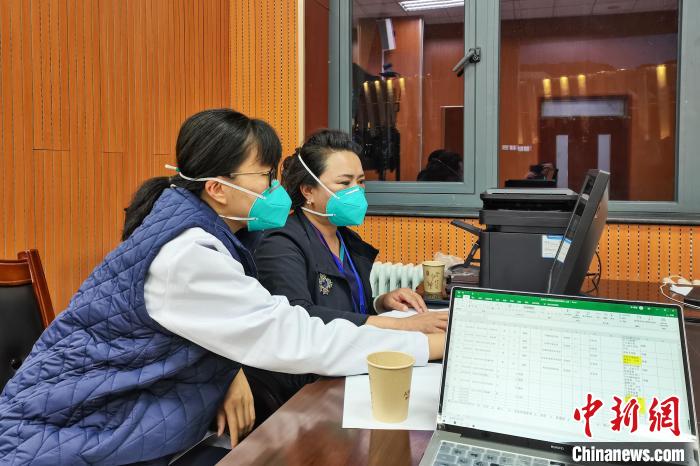 8月9日，楊蘇喬(左)在拉薩方艙醫(yī)院指揮部讀取艙內(nèi)患者胸部CT?！∈茉L者供圖
