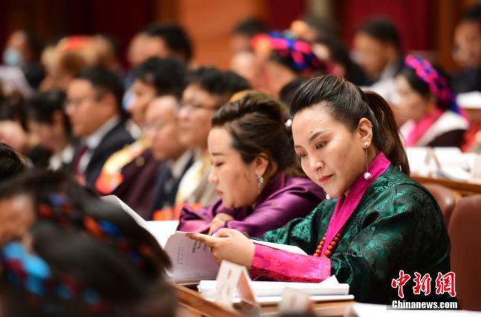 1月5日，次旦卓嘎(右一)在拉薩參加西藏自治區(qū)第十一屆人民代表大會(huì)第五次會(huì)議第二次全體會(huì)議。西藏自治區(qū)人大代表次旦卓嘎來(lái)自日喀則市定日縣，定日縣被稱(chēng)為“洛諧故鄉(xiāng)”，作為西藏民間歌舞，洛諧已被列入中國(guó)國(guó)家非物質(zhì)文化遺產(chǎn)項(xiàng)目名錄，這是集歌、舞、樂(lè)、彈唱于一體的綜合藝術(shù)形式。參加完西藏2022年新年音樂(lè)會(huì)的次旦卓嘎告訴記者，每年參加的基層演出可達(dá)80場(chǎng)，“我希望用最純粹的方式，把最好的聲音帶到西藏乃至中國(guó)的各個(gè)角落?！?<a target='_blank' href='/'><p  align=