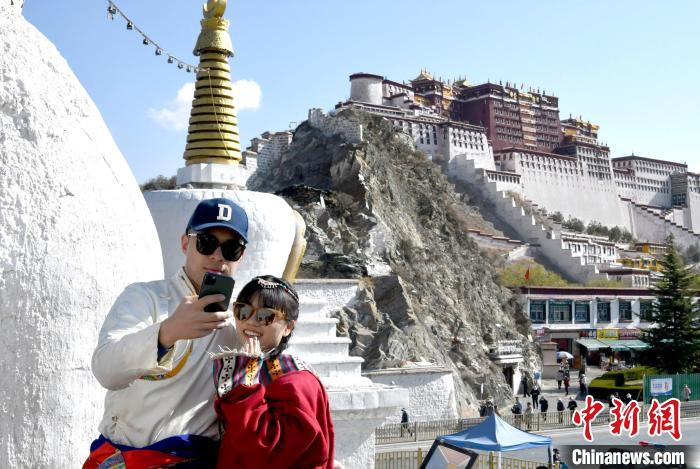 4月17日，游客身著藏式元素服裝在拉薩布達拉宮觀景臺拍照留念?！±盍?攝