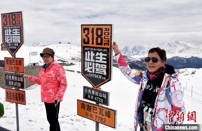 圖為5月14日，西藏林芝色季拉山觀景臺，游客與南迦巴瓦峰合影?！±盍?攝