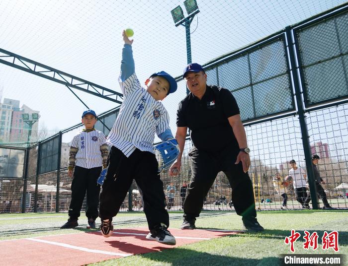 圖為來自臺(tái)灣的棒球教練劉興鴻(右)指導(dǎo)小棒球手?jǐn)S球技術(shù)?！●R銘言 攝