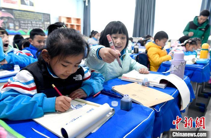 3月14日，西藏拉薩市第一小學(xué)一年級六班學(xué)生白瑪朗珍(圖左)在藏語文課上書寫藏文?！±盍?攝