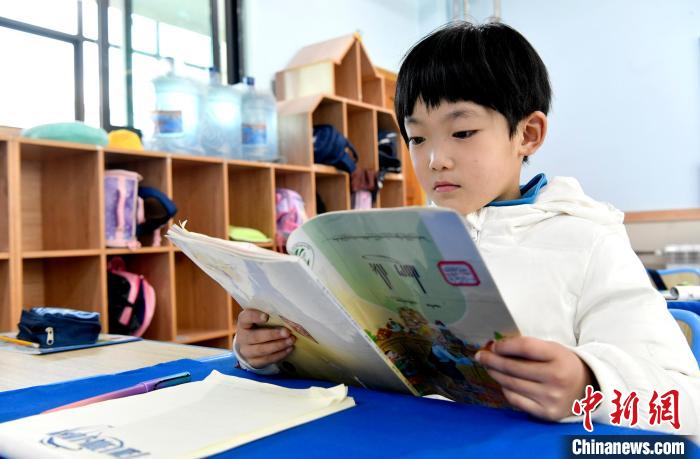 3月14日，西藏拉薩市第一小學(xué)一年級六班學(xué)生丁增樂吉在閱讀藏語課本?！±盍?攝