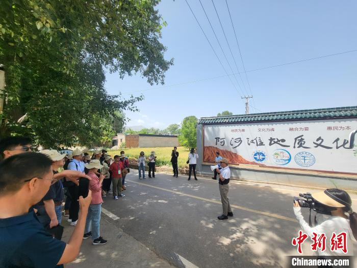 圖為中國地質(zhì)大學(北京)教授張緒教介紹村落情況?！『衍?攝