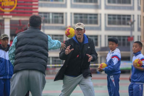 在高原上教孩子們打手球，“慢慢兒來，甭著急！”