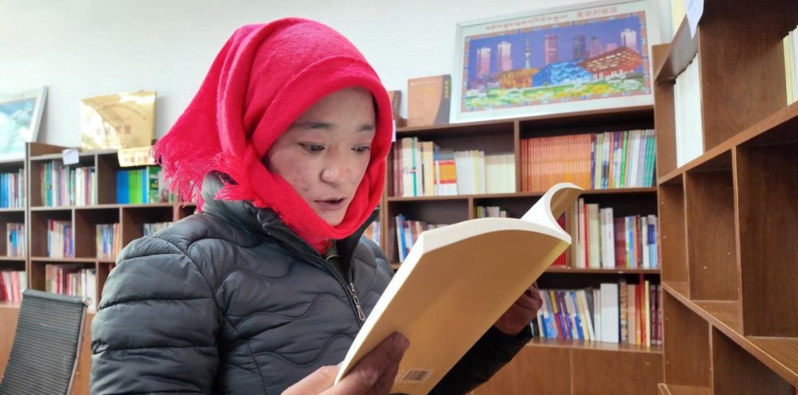 一名婦女正在認(rèn)真閱讀書(shū)籍。申扎縣融媒體中心供圖