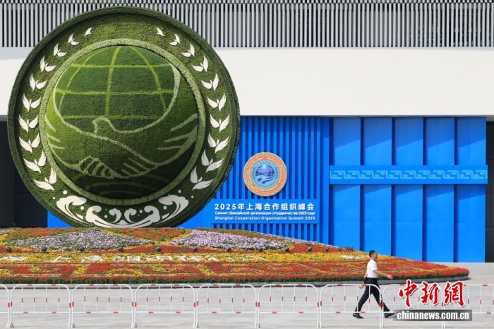 8月31日，天津，一名工作人員從2025年上海合作組織峰會主會場外的景觀花壇旁經(jīng)過。當(dāng)日，2025年上海合作組織峰會在天津舉行。<a target='_blank' href='/'><p  align=