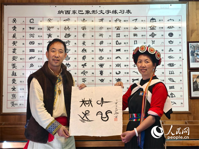 人民網(wǎng)“行進中國”云南調(diào)研采訪團走進麗江，和閏元現(xiàn)場用東巴文寫下“行進中國”。人民網(wǎng)記者 符皓攝