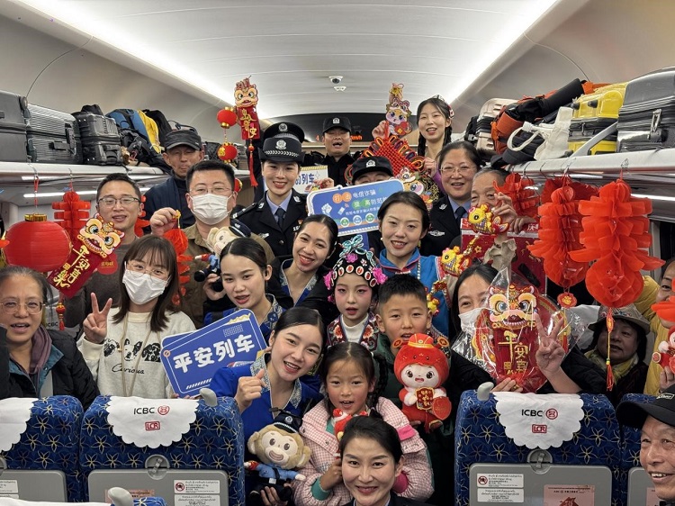 春節(jié)期間，在中老鐵路磨萬（磨丁—萬象）段，鐵路客運員工與乘客合影留念。李加勇攝