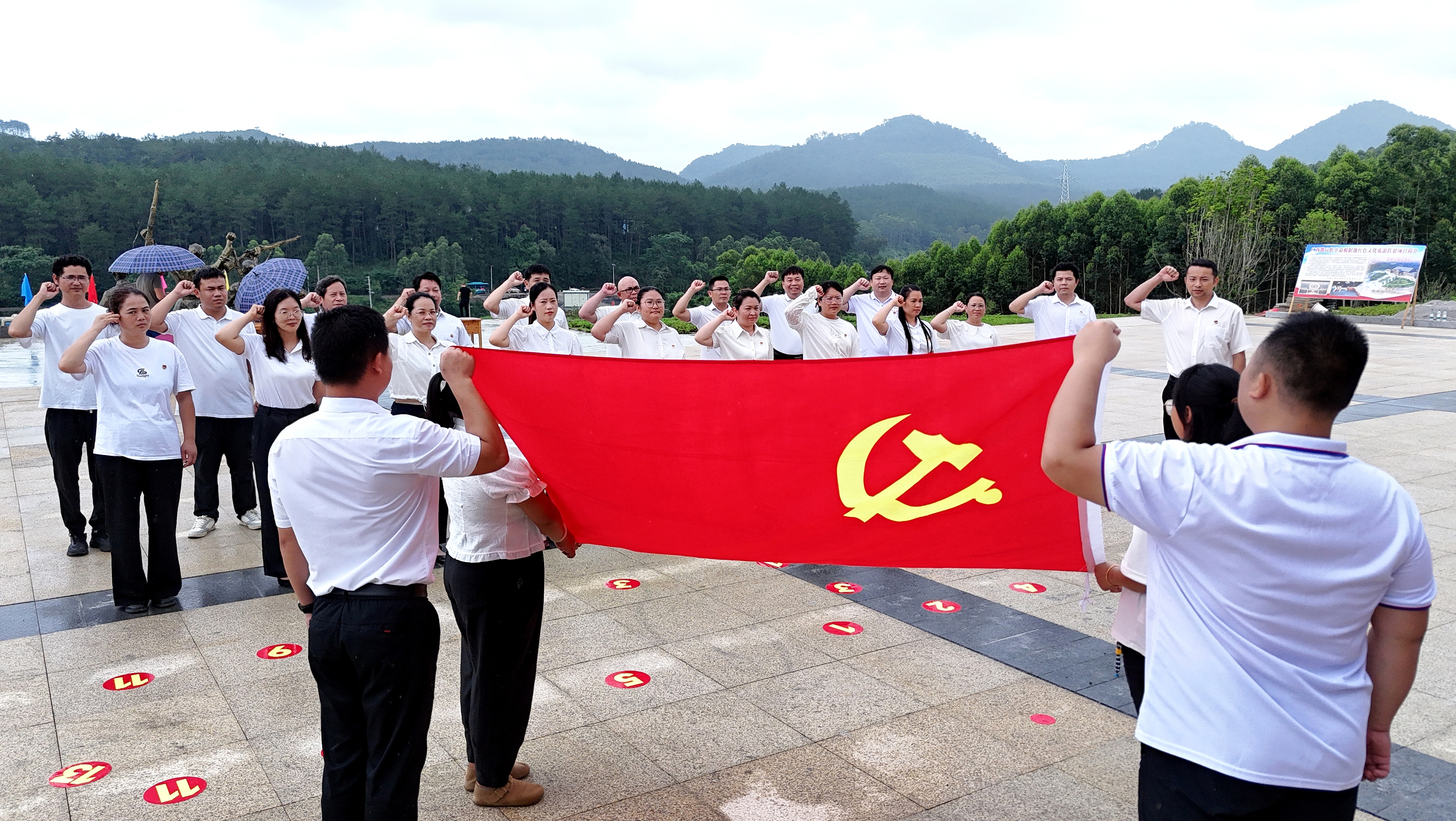 2025年7月1日，廣西都宜忻人民解放總隊紀念館前，黨員面向黨旗重溫入黨誓詞。