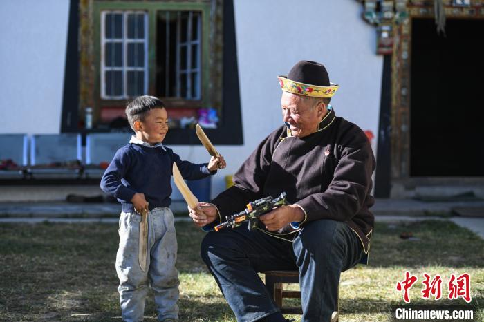 圖為米林縣扎西繞登鄉(xiāng)彩門(mén)村64歲的洛桑帶著孫子巴桑在院子的草地上玩耍?！『闻罾?攝