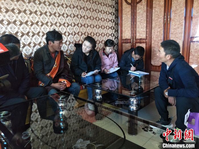 圖為調(diào)查組工作人員正在入戶調(diào)查?！∑钤鲚?攝
