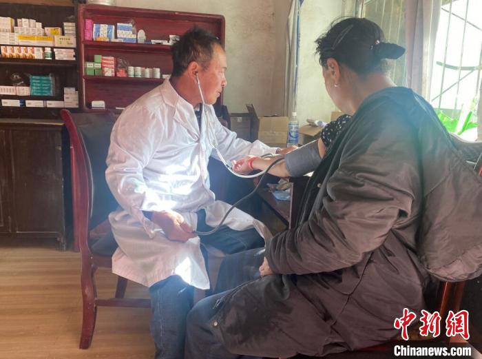 索木滾(左)為村民看病?！∪捞量h委宣傳部供圖