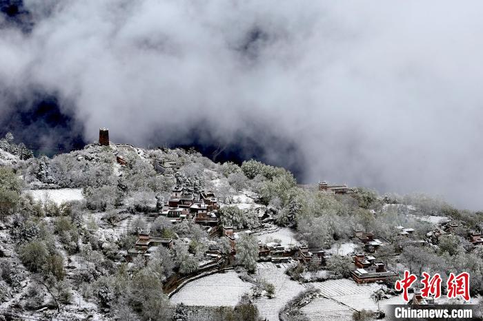 雪后的藏寨和碉樓構(gòu)成美麗的雪景?！〗党鯘衫?攝