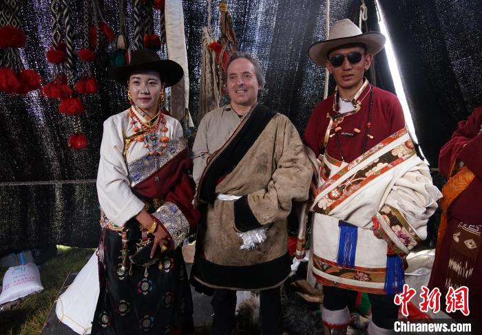 圖為一名外籍?dāng)z影師(中)身穿藏服和藏族民眾合影留念?！●R銘言 攝