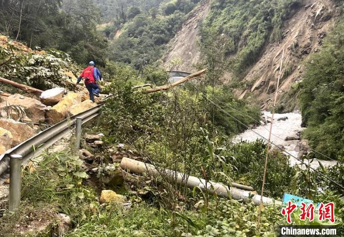 電力搶險人員快速通過危險路段，旁邊是受損的電力線路 四川電力供圖
