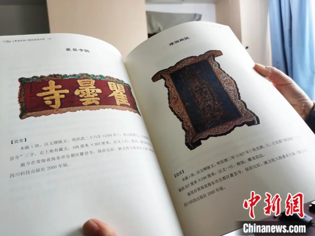 古籍保護(hù)人員展示介紹明代朱元璋撰寫的青海瞿曇寺匾(左)的出版書籍。張?zhí)砀?攝
