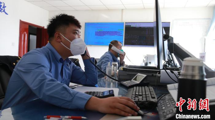 圖為貨運調(diào)度人員與外勤工作人員聯(lián)系掌握車輛裝載情況?！±钌?攝
