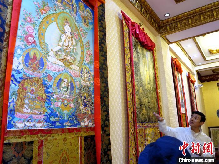 圖為完德尖措展示熱貢龍樹畫苑內的唐卡?！?zhí)砀?攝