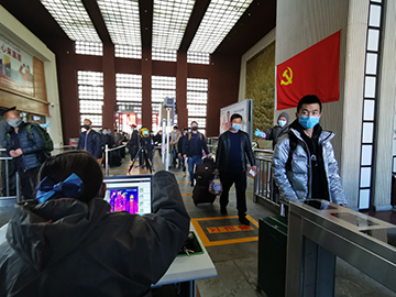 拉薩火車站工作人員對出站旅客進行紅外線測溫。趙越拍攝.jpg