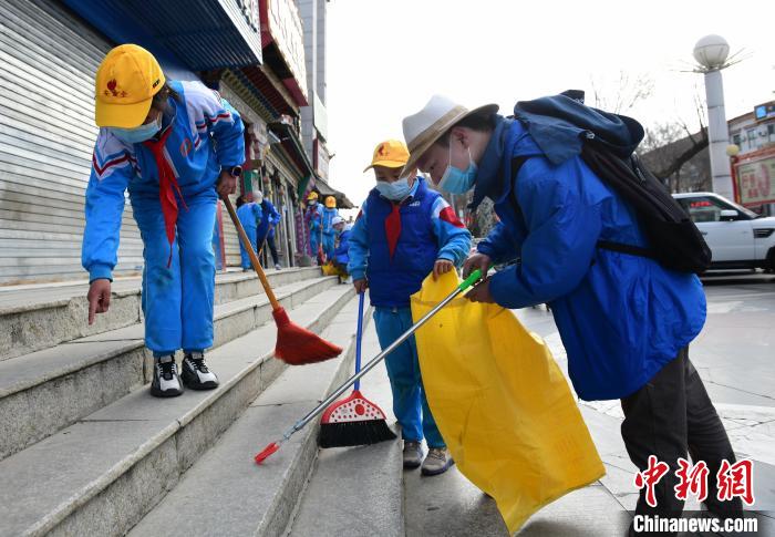圖為拉薩市小學(xué)生打掃街道?！∝暩聛硭?攝