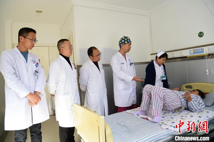 圖為何蔚副主任醫(yī)師(站右二)及團隊術(shù)后指導患者進行腰背肌鍛煉。　貢嘎來松 攝