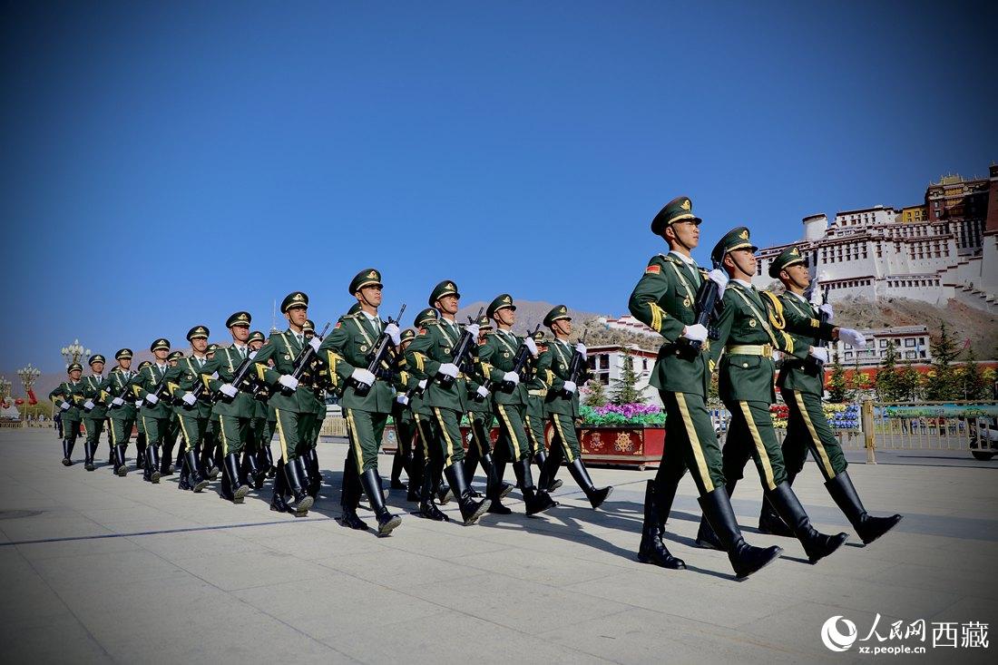 國(guó)旗護(hù)衛(wèi)隊(duì)隊(duì)員緊握鋼槍，踏著威武雄壯的步伐，走向國(guó)旗臺(tái)。人民網(wǎng) 次仁羅布攝