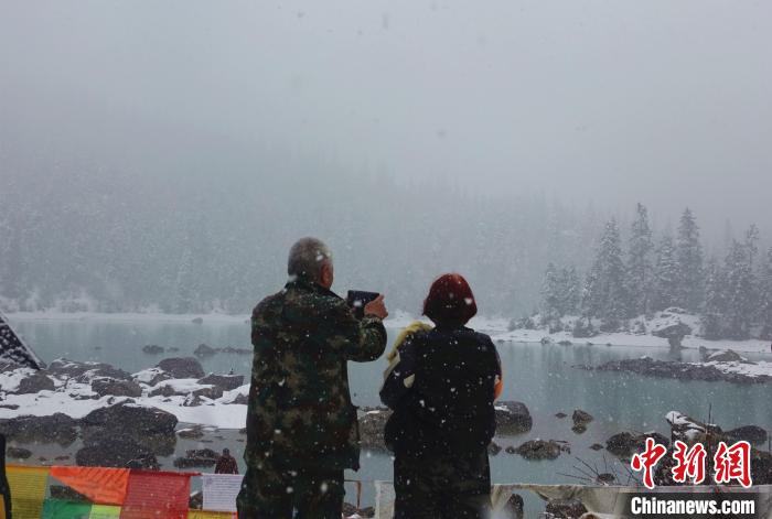 游客欣賞雪中然烏湖。　冉文娟 攝