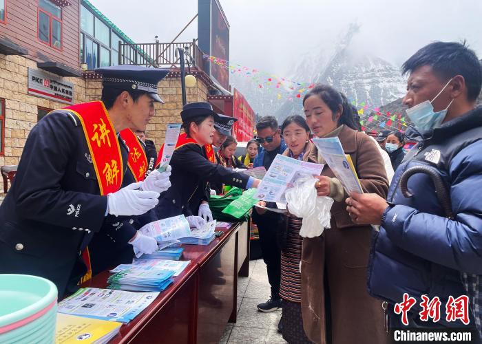圖為山南玉麥邊境派出所民警為轄區(qū)群眾發(fā)放法律知識宣傳單。　鐘鑫 　攝
