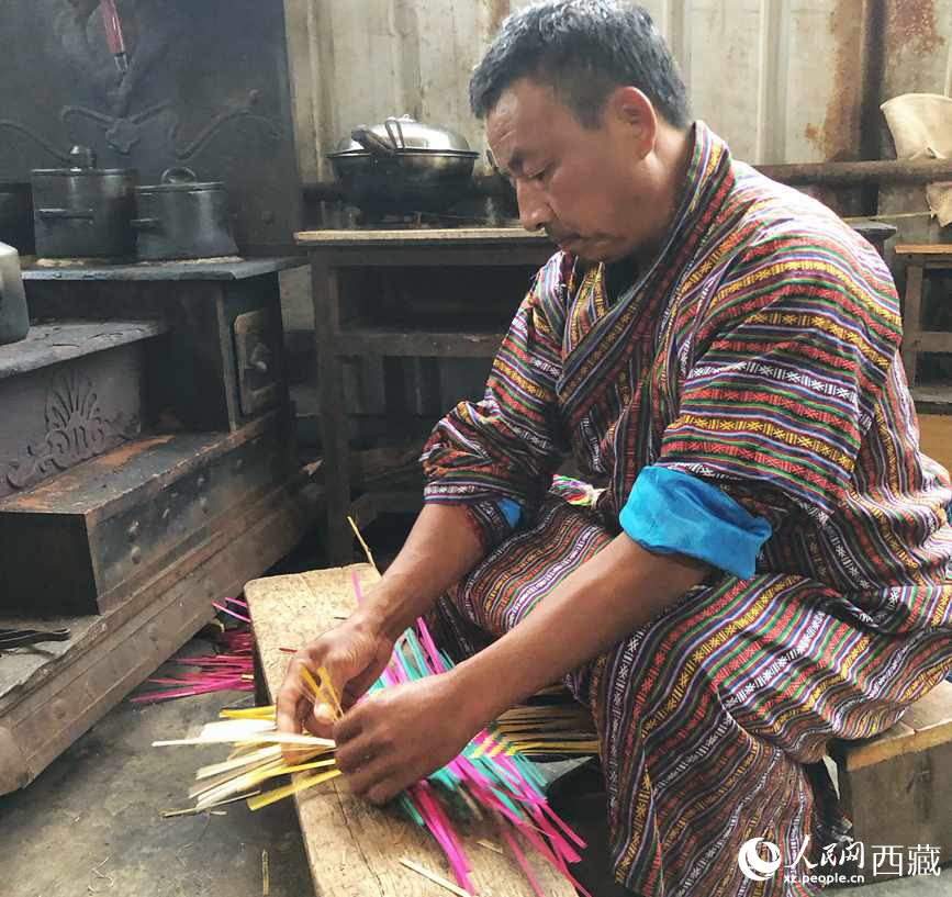 門巴族漢子愛明正在編織藤竹品。