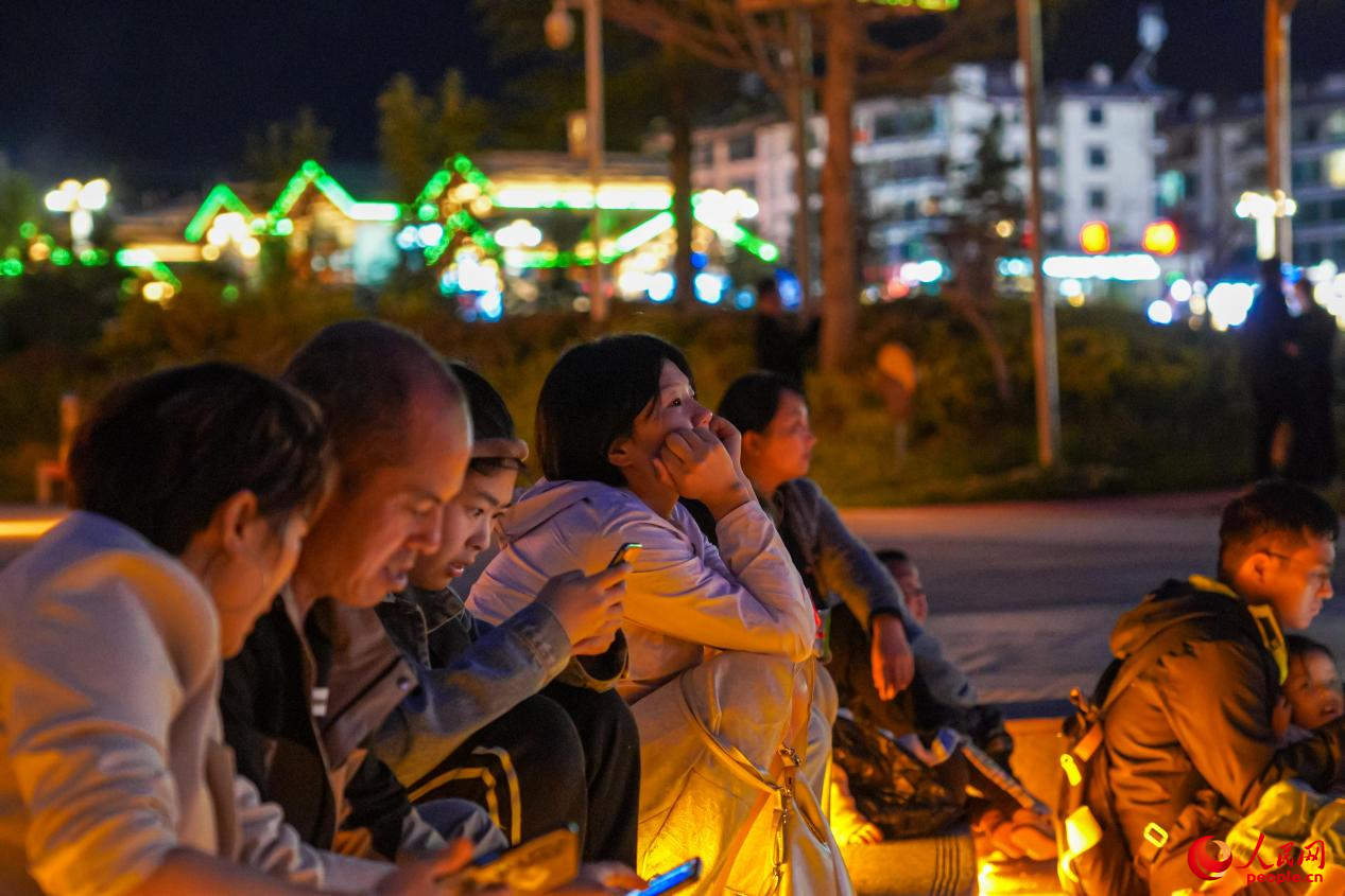 市民坐在西藏林芝市民族團結廣場臺階上欣賞音樂噴泉。人民網(wǎng)記者 趙晨攝